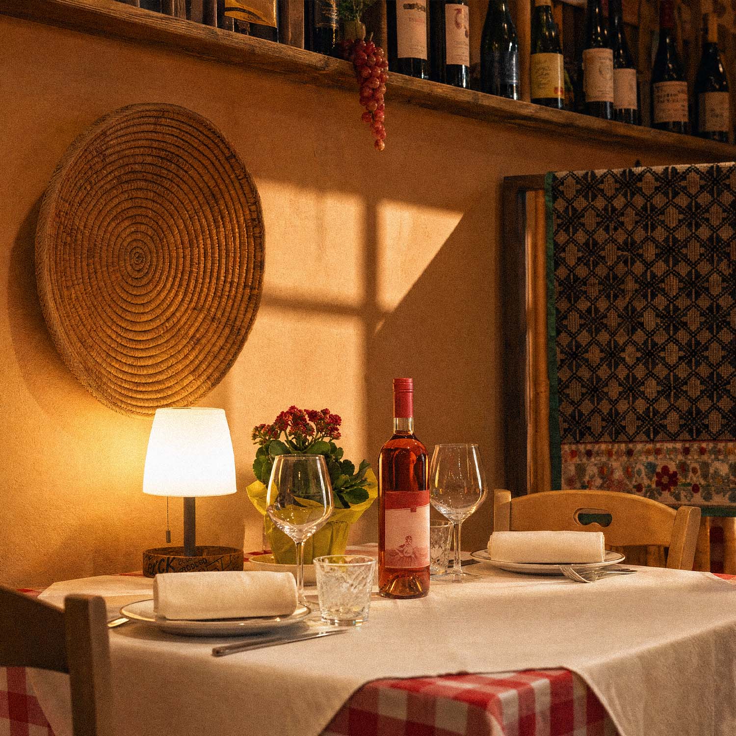 Tavolo apparecchiato con vino e luce ambrata